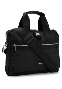 Sac à bandoulière rectangulaire noir avec double poignée, sangle réglable, poche avant zippée et logo « BOSS » sur la partie inférieure avant.