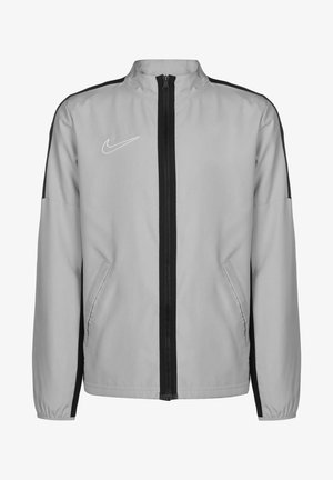 Grijze jas met zwarte zijkanten, rits aan de voorkant, twee zijzakken en een hoge kraag; heeft een klein wit Nike-logo op de borst.