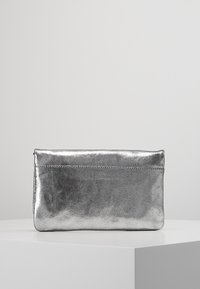 Borsa clutch metallizzata argento con una texture liscia, forma rettangolare e dettaglio cucitura superiore. Design minimalista, adatto per diverse occasioni.