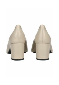 Béžové kožené boty na blokovém podpatku s designem špičaté špičky, s hladkým povrchem a kontrastní černou podrážkou.