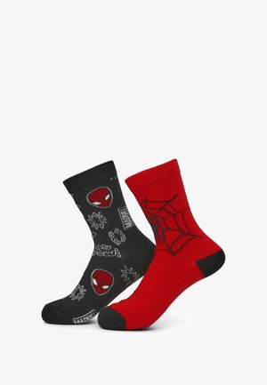 Czarne i czerwone skarpetki z wzorami Spidermana. Czarna skarpeta ma różne białe grafiki superbohaterów, podczas gdy czerwona skarpeta ma wzór pajęczej sieci.
