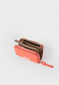 Koronkowy portfel z zamknięciem na zamek, z gładką powierzchnią, brązowym wnętrzem, kieszonkami na karty kredytowe i czerwonym pomponem przy zamku.