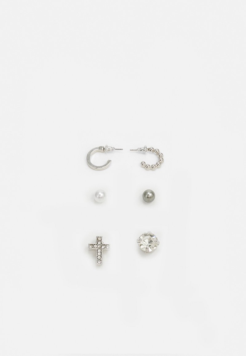 Set di sei orecchini che include un orecchino a cerchio in argento, una catena in argento, perle bianche e grigie, una croce in argento e una gemma trasparente, in varie forme e design.
