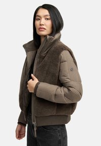 Bruine, cropped jas met een pluizige faux fur voorkant, gestikte mouwen, een hoge kraag en ribgebreide manchetten. Ritsluiting en logo detail op de mouw.