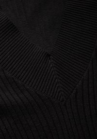 Pull en tricot noir avec un décolleté en V profond, présentant une texture côtelée et des motifs de tricot diagonaux au niveau du col et du corps.