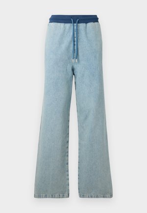 Calças de denim de perna larga em azul claro com um cós elástico azul escuro e cordão correspondente com extremidades em metal.