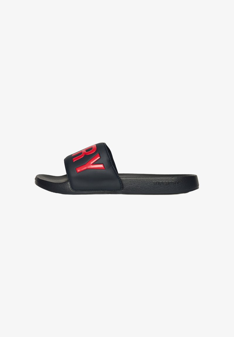 Chausson de bain noir avec une large sangle arborant une inscription "SUPERDRY" rouge audacieuse. Semelle en caoutchouc souple, texture lisse et design minimaliste.