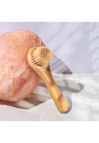 Bambooowa szczoteczka do twarzy z zaokrągloną główką z miękkim włosiem, oparta na różowej soli kamiennej. Gładki uchwyt o naturalnym wykończeniu.