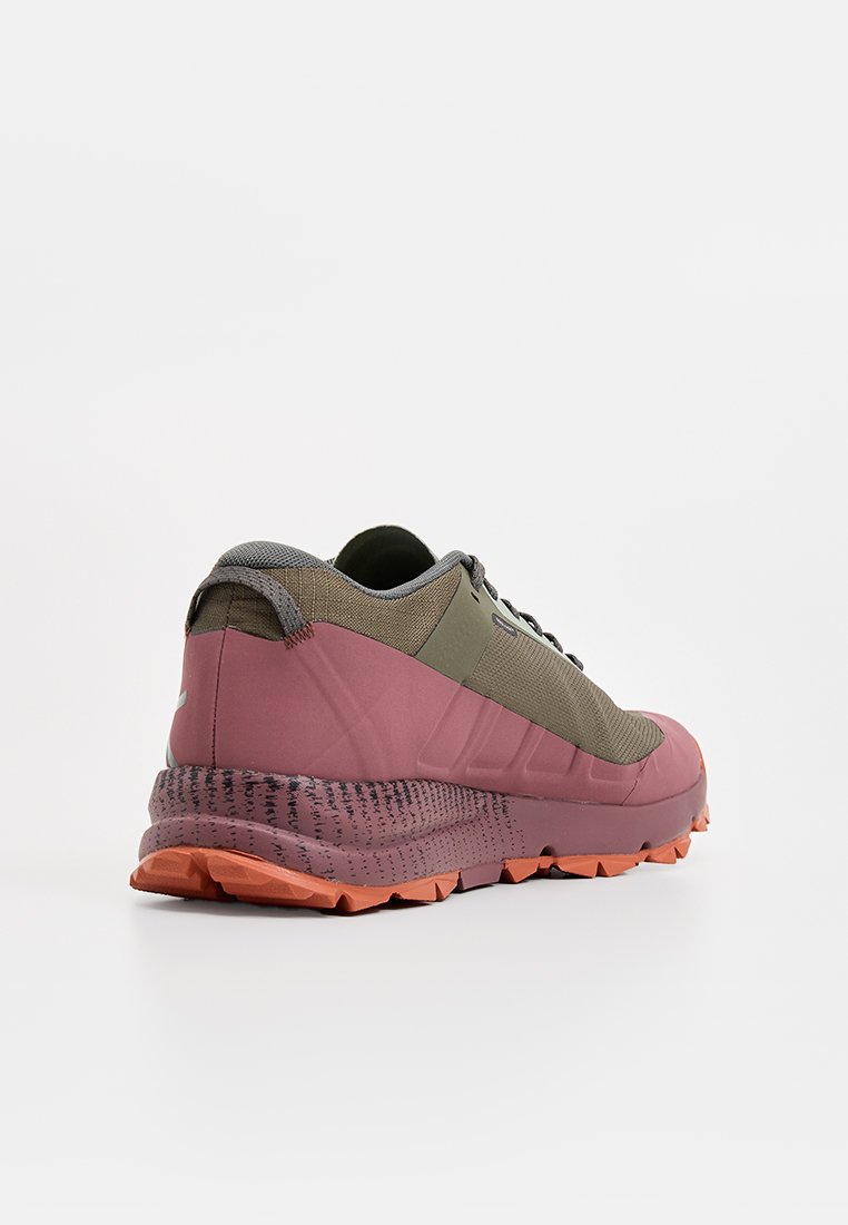 Chaussure de trail running avec un design multicolore en vert olive et rose, tige texturée et semelle extérieure robuste orange avec un motif de crampons.