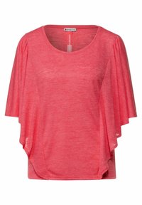 Koralowy różowy top wykonany z lekkiego materiału; posiada krótkie rękawy i luźny, zwiewny krój z subtelną fakturą oraz okrągły dekolt.