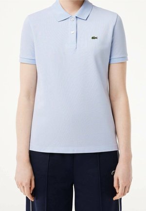 Lichtblauw poloshirt met korte mouwen, klassieke kraag, drie knopen en groen geborduurd logo. Gemaakt van gestructureerde stof.