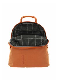 Sac à dos en maille orange avec un haut arrondi, présentant un intérieur ouvert doublé de tissu noir affichant le nom de la marque dans un motif répétitif.