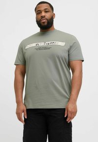 Oliven grøn t-shirt i bomuld med et stort grafisk tryk "JACK & JONES" tværs over forsiden i hvidt og gråt, rund halsudskæring, korte ærmer.