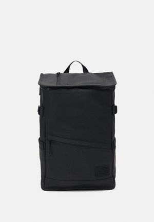 Mochila preta com design de topo enrolável, feita de tecido durável. Apresenta um bolso frontal com fecho e tiras laterais ajustáveis. Detalhe de superfície texturizada.