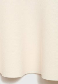 Tessuto color crema con una superficie tessurizzata, caratterizzato da un motivo intrecciato morbido. I bordi sono rifiniti in modo uniforme, creando una leggera caduta.