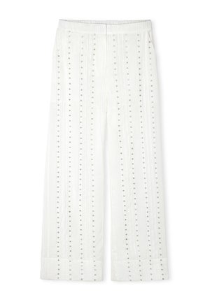 Pantalons larges blancs avec des rangées verticales de clous argentés, une taille élastique et un tissu texturé. Les ourlets retroussés complètent le design.