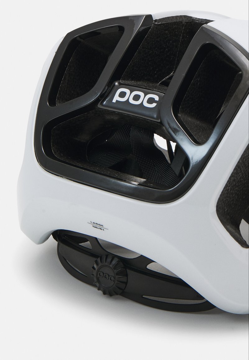 Weißer Helm mit schwarzen Akzenten; verfügt über Belüftungsöffnungen und einen einstellbaren Drehknopf für die Passform. Das 'POC'-Logo ist an der Seite sichtbar.