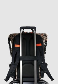 Zaino a rotelle con schiena beige decorata, spallacci imbottiti neri, maniglia argentata e dettagli arancioni; presenta particolari in rete traspirante.