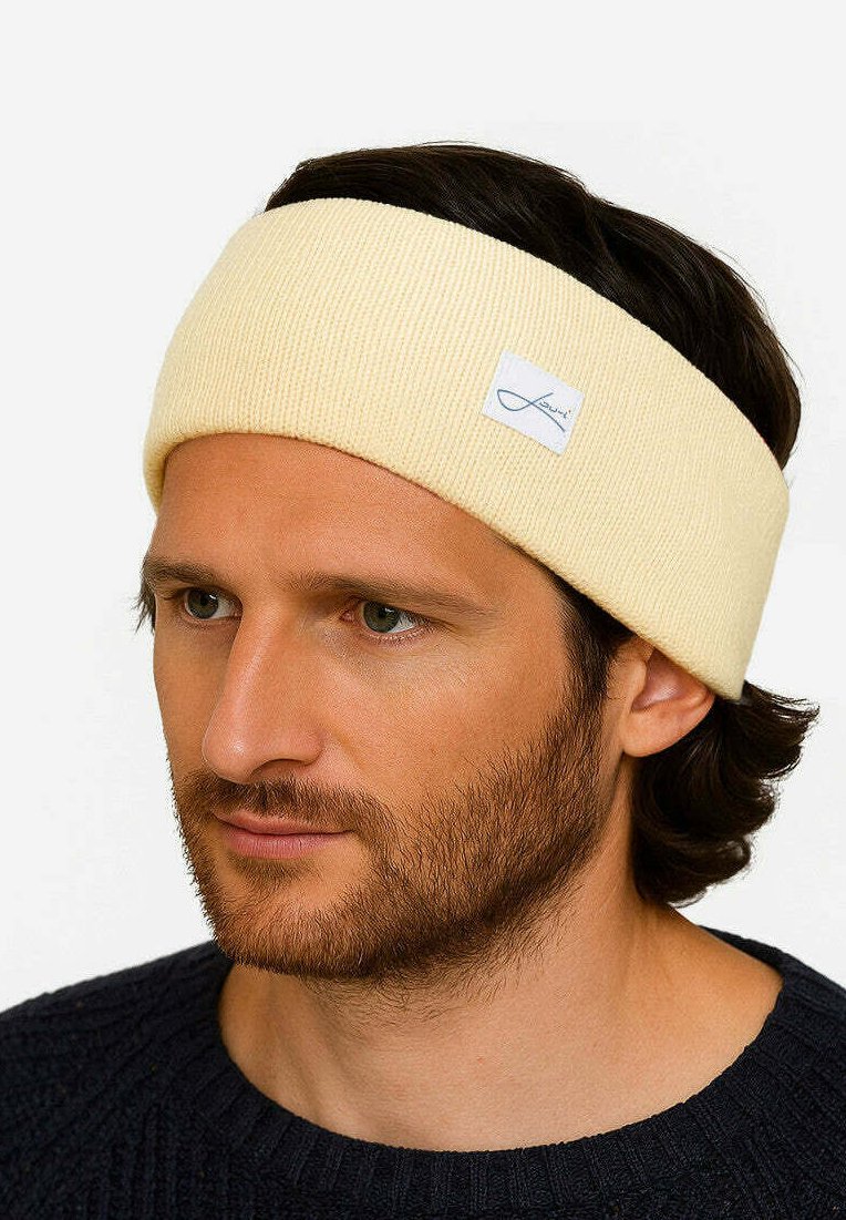 Gelbes, geripptes Stoffhaarband mit einem gestickten Logo-Tag, das über dunklem Haar getragen wird, mit einer glatten Textur und mittlerer Breite.