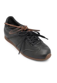 Baskets en cuir noir avec lacets noirs et un lacet marron noué en nœud, semelle en caoutchouc marron, détails de couture, étiqueté fabriqué en Pologne.