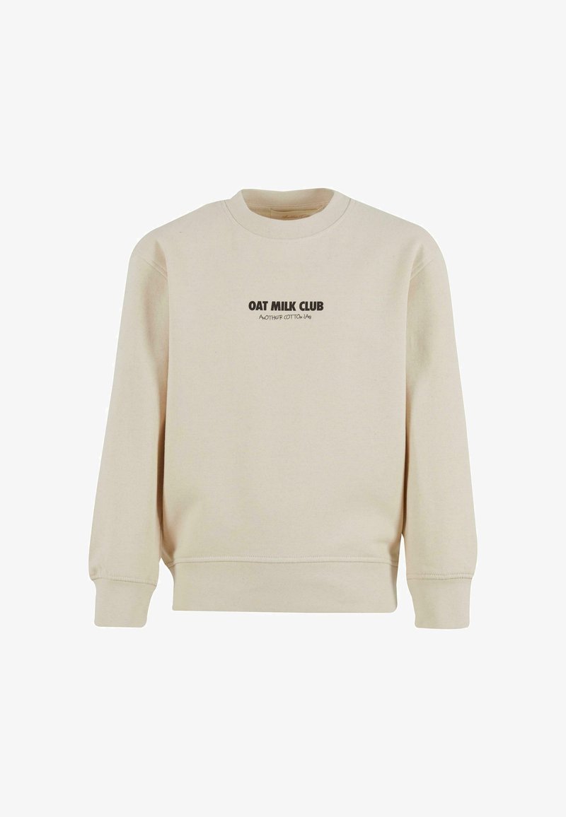 Beige bomullströja med rund halsringning, ribbstickade ärmslut och nederkant. Har "OAT MILK CLUB" tryckt i mörkbrunt på framsidan.