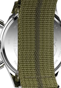 Bracelet de montre en tissu vert avec un tissage texturé, boîtier en acier inoxydable et fond de boîte transparent affichant le marquage de résistance à l'eau.