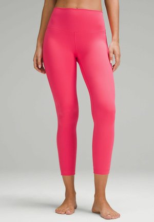 Rosa High-Waist-Leggings mit glattem, dehnbarem Material, die einen enganliegenden Schnitt und eine cropped Länge bis zur Mitte der Wade haben.