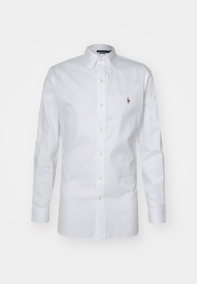 Λευκό πουκάμισο με κουμπιά φτιαγμένο από βαμβάκι; διαθέτει κλασικό γιακά, μακρύ μανίκι και ένα μικρό κεντητό λογότυπο στο αριστερό στήθος.