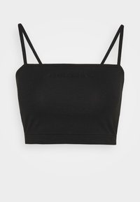 Svart crop top i mjukt tyg med tunna band och en sömlös design. Har ett upphöjt logo på framsidan och en åtsittande passform.