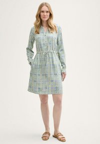 Langärmliges Hemdkleid in Hellgrün mit einem karierten Muster in Blau und Gelb, ausgestattet mit einem Bindegürtel in der Taille und seitlichen Taschen.