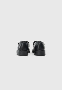 Černé kožené boty s hladkým povrchem, zaoblenou špičkou a nízkými podpatky. Prošívání po stranách. Minimalistický design.