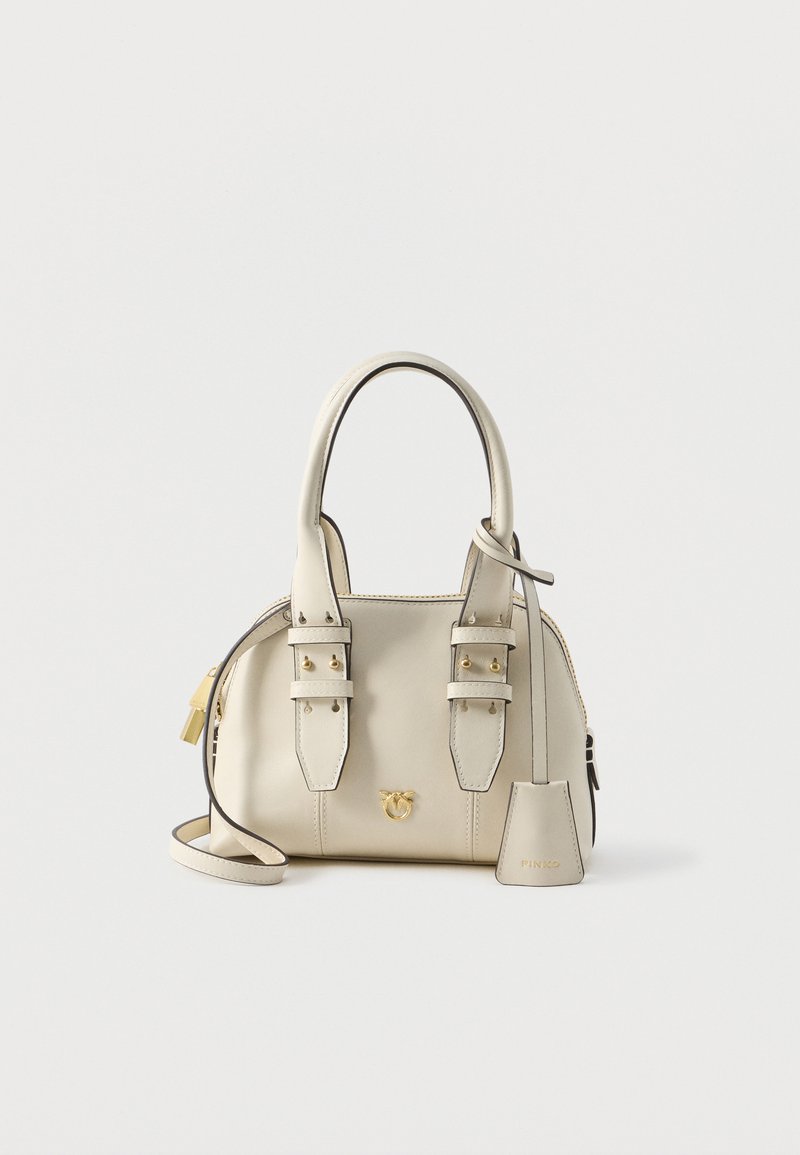 Pequena bolsa de couro bege com duas alças superiores, detalhes em hardware dourado e alça de ombro destacável. Apresenta tiras decorativas e etiqueta da marca.