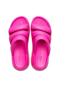 Różowe gumowe klapki z dwiema szerokimi paskami, teksturowaną wkładką oraz gładkim wykończeniem. Marka widoczna wewnątrz wkładki.