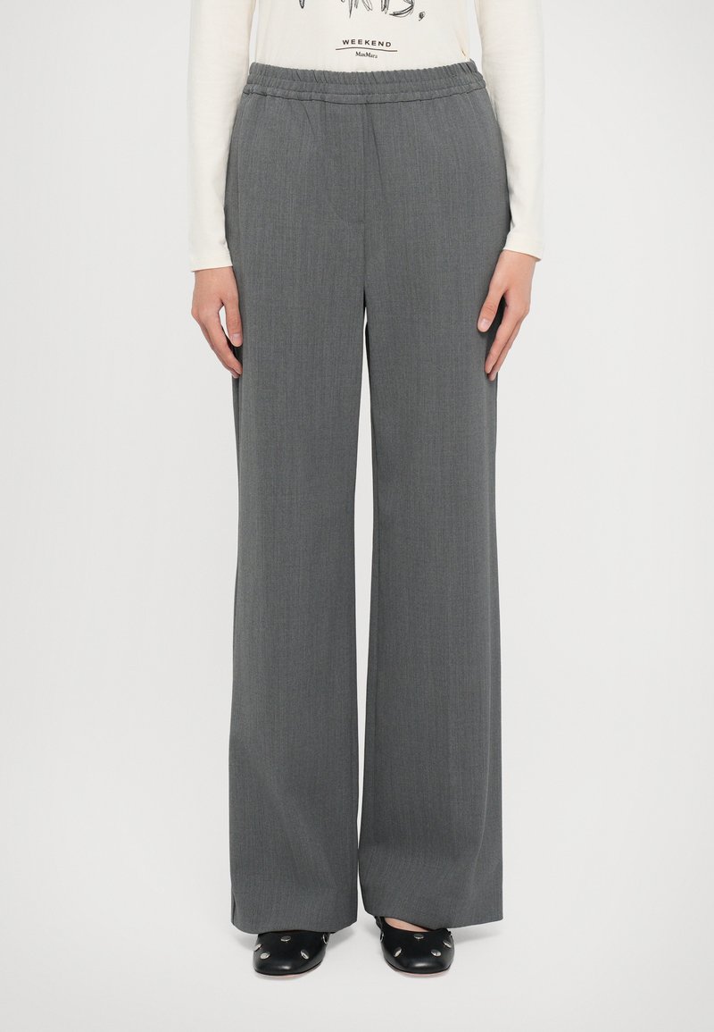 Gray wide-leg trousers made from textured fabric with an elastic waistband. Paired with a white long-sleeve shirt and black shoes.