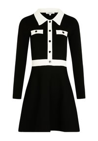 Vestido negro con mangas largas, cuello blanco en contraste y tapeta de botones, dos bolsillos en el pecho y un diseño de falda acampanada.