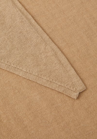 Beige knit fabric with a smooth texture, featuring a pointed design at the edge and neat stitching along the border.
