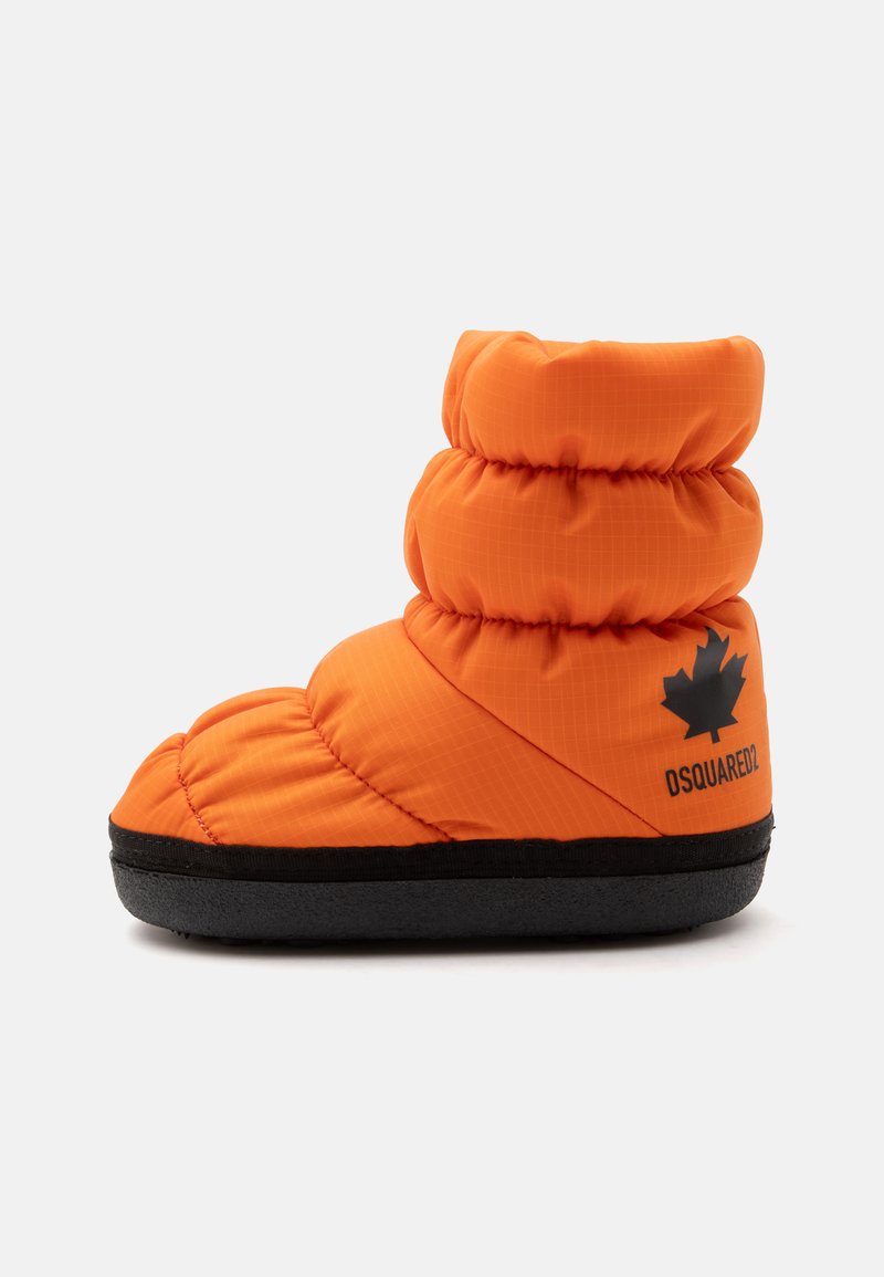 Botte d'hiver matelassée orange vif avec une semelle noire, avec un logo feuille d'érable noir et le texte "DSQUARED2" sur le côté.