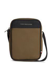 Τσάντα χιαστί Tommy Hilfiger σε ελαιί πράσινο με μαύρη διακόσμηση, εμπρόσθια τσέπη με φερμουάρ, ρυθμιζόμενο μαύρο λουρί και μικρή σημαία στο πλάι.