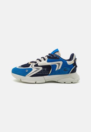 Blauer, navyblauer und weißer Sportschuh mit Mesh- und Wildlederdetails, weißer Sohle und strukturierten Designakzenten auf schlichtem Hintergrund.