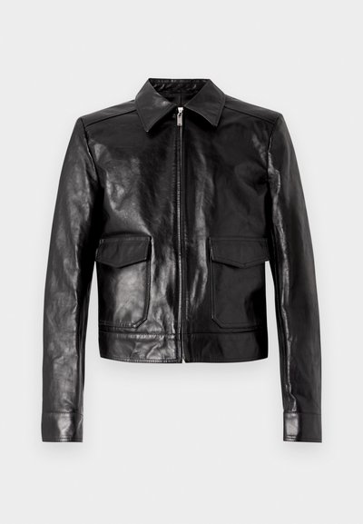 Melnā ādas jaka ar izteiktu apkakli, priekšējo rāvējslēdzēju un divām kabatām. Gluda tekstūra ar pieguļošu dizainu un pielāgotu apdari.