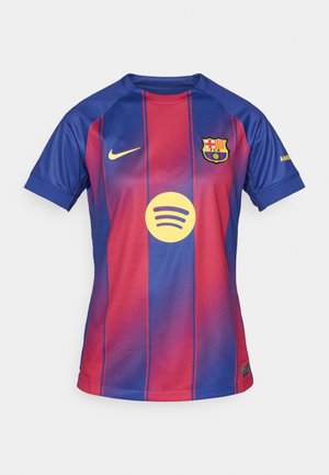 Dres FC Barcelona s gradientem tmavě modré a červené barvy, se zlatým logem Nike, znakem klubu a kulatým logem Spotify v žluté barvě.