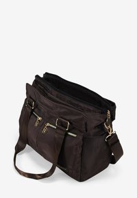 Bolsa de tote de nailon marrón con forma estructurada, compartimentos de almacenamiento duales, acentos de hardware dorado y correa para el hombro ajustable.