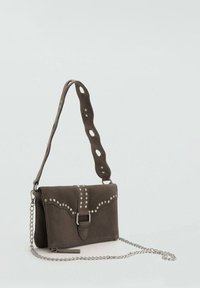 Sac en daim marron avec une bandoulière chaîne, doté d'une fermeture à boucle et de clous décoratifs le long du devant et de la bandoulière.