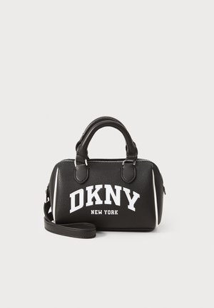 Musta nahkainen käsilaukku, jossa on teksturoitu pinta, valkoinen brändäys "DKNY NEW YORK", pyöreät yläkahvat, irrotettava olkahihna ja hopeinen vetoketju.