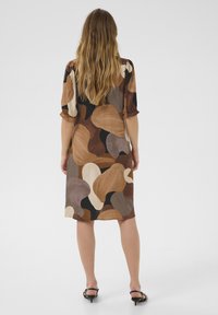 Short-sleeve dress featuring an abstract pattern in shades of brown, beige, and black. Smooth fabric with a relaxed fit and knee-length cut.