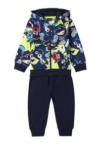 Set bestehend aus Kapuzenpullover und Hose in Marineblau. Der Kapuzenpullover hat bunte Cartoonfiguren auf schwarzem Hintergrund; die Hose ist in einem einfarbigen Marineblau mit elastischen Bündchen.