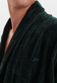 Tmavě zelený, texturovaný župan se šálovým límcem. Má jemně vyšívané logo "Jbs" na hrudi a kontrastní lemování podél okrajů.