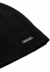 Czarna dziana czapka z podwinięciem, z prążkowaną teksturą i małą czarną metką marki z boku.