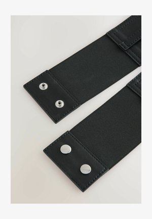 Schwarzes elastisches Band mit zwei Lederenden und silbernen Druckknöpfen. Glatte Textur mit robuster Naht entlang der Kanten.