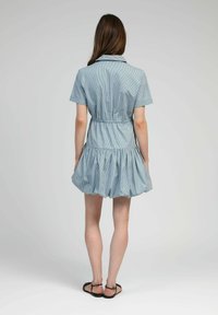 Robe courte à rayures bleues avec un col, taille élastique et jupe évasée superposée. Tissu lisse avec une texture légère.